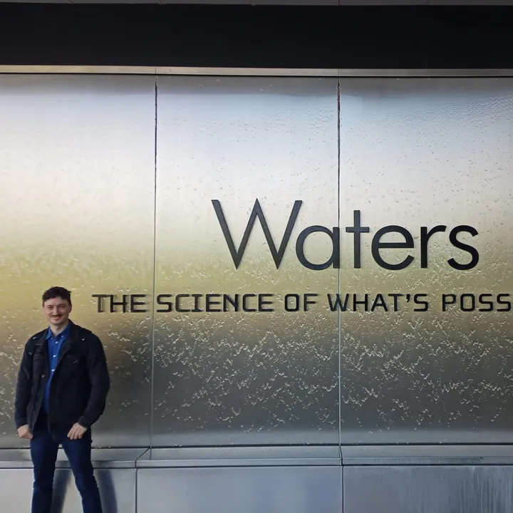 Guy Entract in front of the Waters sign